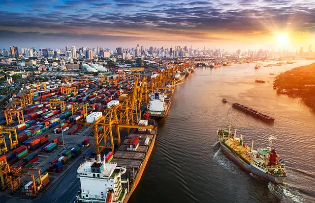 Container port and city skyline at sunset